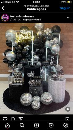 a bunch of silver and black balloons are on display