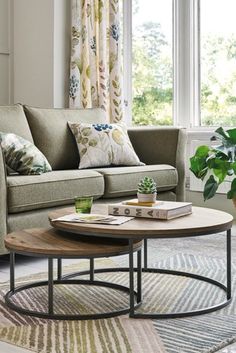 a living room with two couches and a coffee table in front of the window