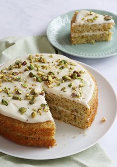 there is a cake with white frosting and pistachios on it