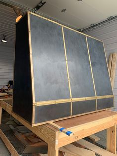 the back end of a large piece of furniture being assembled in a garage with wood and plywood