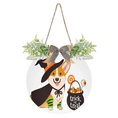 a christmas ornament with a dog wearing a witch hat and holding a trick bag