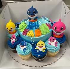 a birthday cake decorated with cupcakes and toys