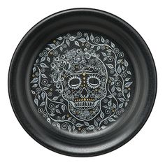 a black plate with a skull and leaves on it