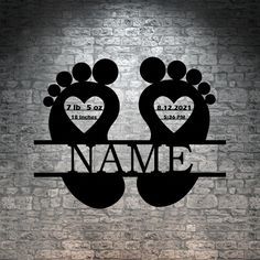 two feet with hearts and name in the middle on a metal shelf against a brick wall