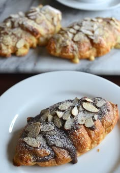 two white plates topped with pastries on top of a table