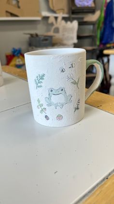 a white coffee cup sitting on top of a table