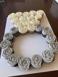 cupcakes arranged in the shape of a heart on top of a card board