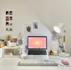 an open laptop computer sitting on top of a white desk next to a keyboard and mouse