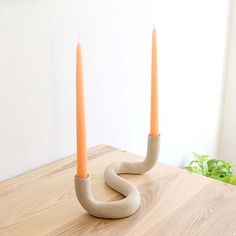 two candles sitting on top of a wooden table