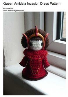 a crocheted doll is sitting on a window sill