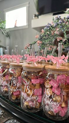 jars filled with pink and gold candies on top of a table