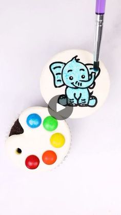 a cupcake with an elephant on it next to a paintbrush and some candy