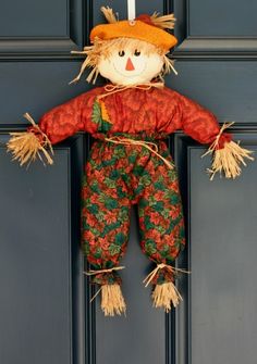 a scarecrow doll hanging on the front door