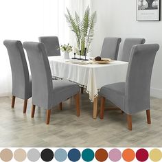 a dining room table with six chairs and a white table cloth on it, surrounded by color swatches