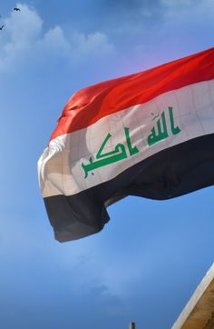 the flag of iraq is flying high in the sky