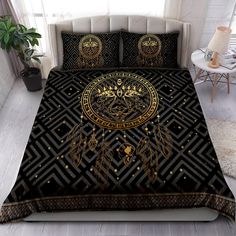 a bed covered in black and gold sheets with an intricate design on the comforter