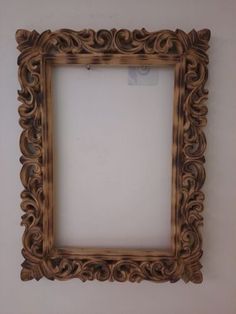 an ornate wooden frame hanging on the wall