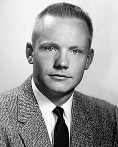 a man in a suit and tie posing for a photo with his head turned to the side