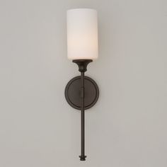 a wall mounted light with a white shade on it's side and a black metal arm