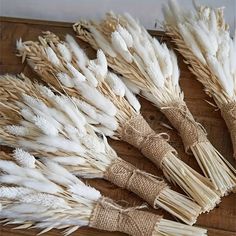 some white feathers are laid out on a wooden board with burlocks and twine