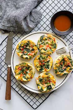 an overhead view of several small muffins with spinach and cheese on a plate