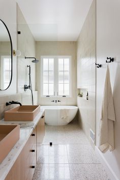 a large bathroom with two sinks and a bathtub in the middle of the room