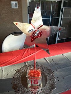 a silver star decoration on top of a table with red and white decorations around it