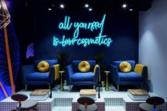 a room with blue couches and neon lights on the wall above them is an advertisement that says, all you need is bio - organicics