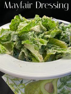 a white plate topped with lettuce on top of a table