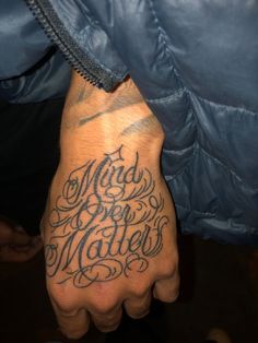 a man with a tattoo on his hand that says mad for matters written in cursive writing