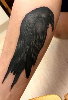 a black bird tattoo on the leg