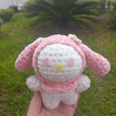 a hand holding a small crocheted hello kitty doll in it's palm