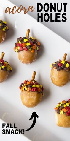 small donuts decorated with candy and sprinkles are on a white plate