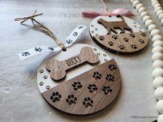 two wooden ornament with dog's name and paw prints on them