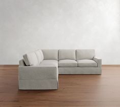 a white couch sitting on top of a hard wood floor next to a wooden floor