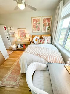 a bed sitting next to a window in a bedroom on top of a hard wood floor