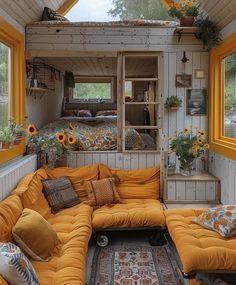 a living room filled with furniture and sunflowers on the windows sill,