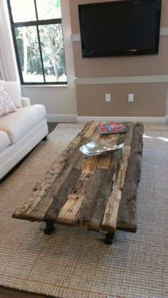 a living room with a couch, coffee table and flat screen tv on the wall