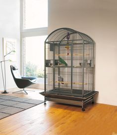 a bird cage sitting on top of a wooden floor