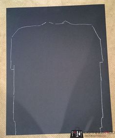 a black piece of paper that has been cut out to look like a man's shirt