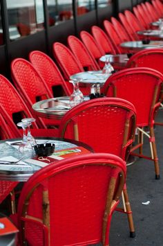 rows of red chairs and tables with silverware on them