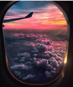 the view from an airplane window shows clouds and sunsets in the sky as well