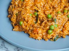 a blue plate topped with rice and peas