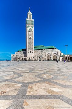 a large white building with a clock on it's face in front of a blue sky