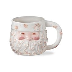 a ceramic mug with a santa claus face on it's side and snowflakes around its head