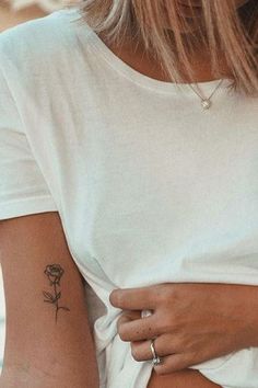 a woman with a rose tattoo on her arm