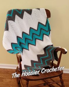 a crocheted blanket sitting on top of a wooden chair