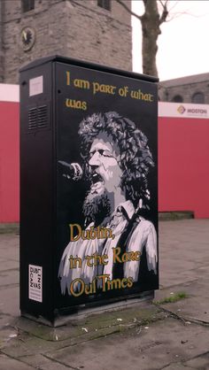 a black box with an image of a man singing into a microphone on the street