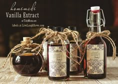 three bottles of vanilla extract sit on a wooden table with twine and twine