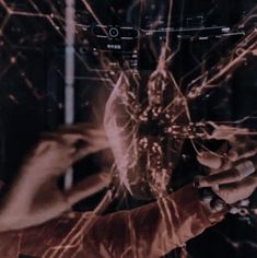 a person holding a cell phone in front of their face with wires all over them